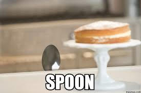 cake on a plate with a spoon peaking from under the table with text 'spoon'